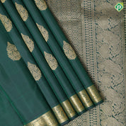 Bottle green gold zari fancy thilagam butta design self color gold zari peacock elephant butts edge border traditional silk saree