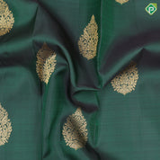 Bottle green gold zari fancy thilagam butta design self color gold zari peacock elephant butts edge border traditional silk saree